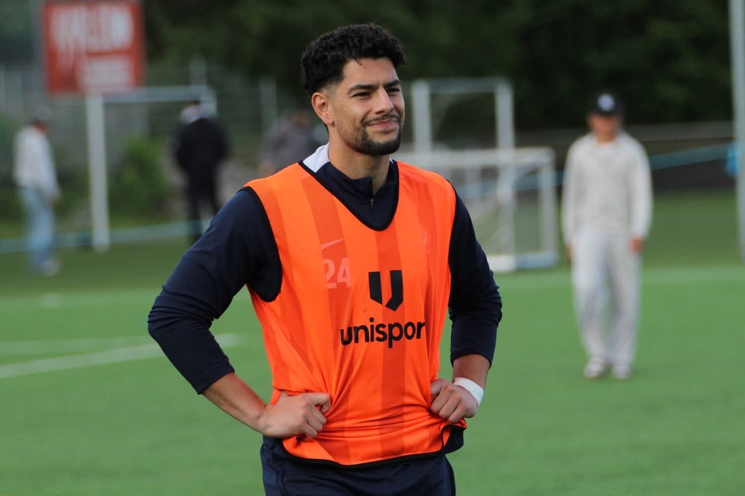 Pouya on the football pitch wearing an orange training bib