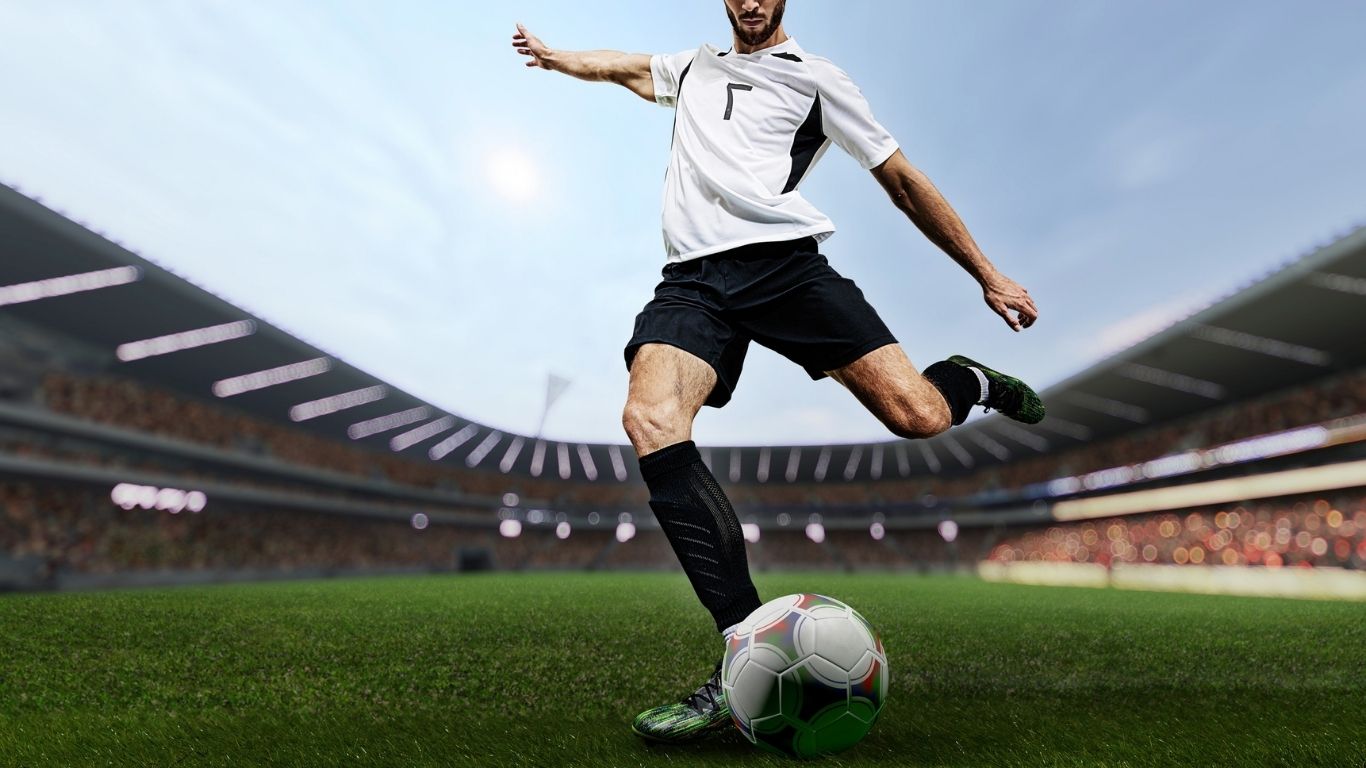 Football player kicking ball in stadium